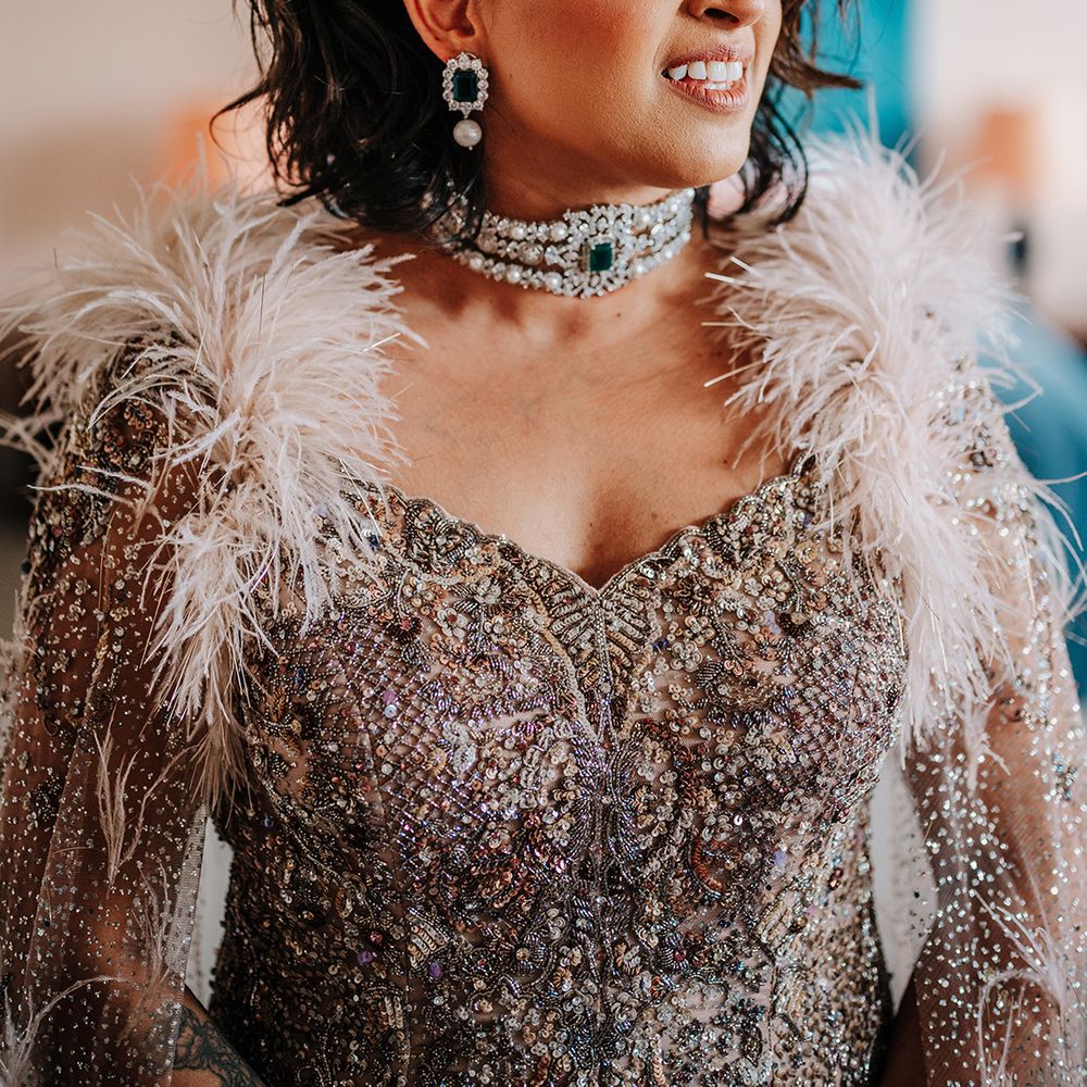 bride-wearing-beaded-feather-wedding-dress-with-choker-necklace-and-earrings