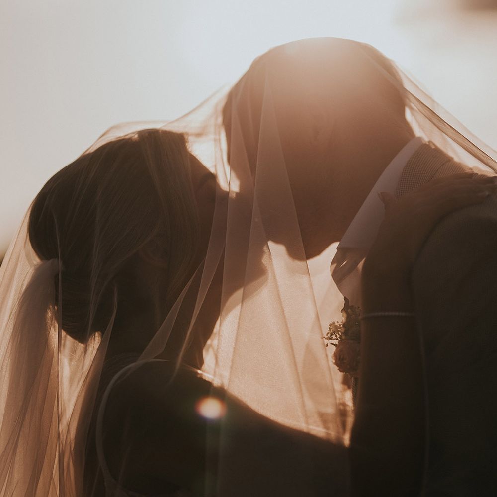 bride-and-groom-kissing-under-bride-wedding-veil