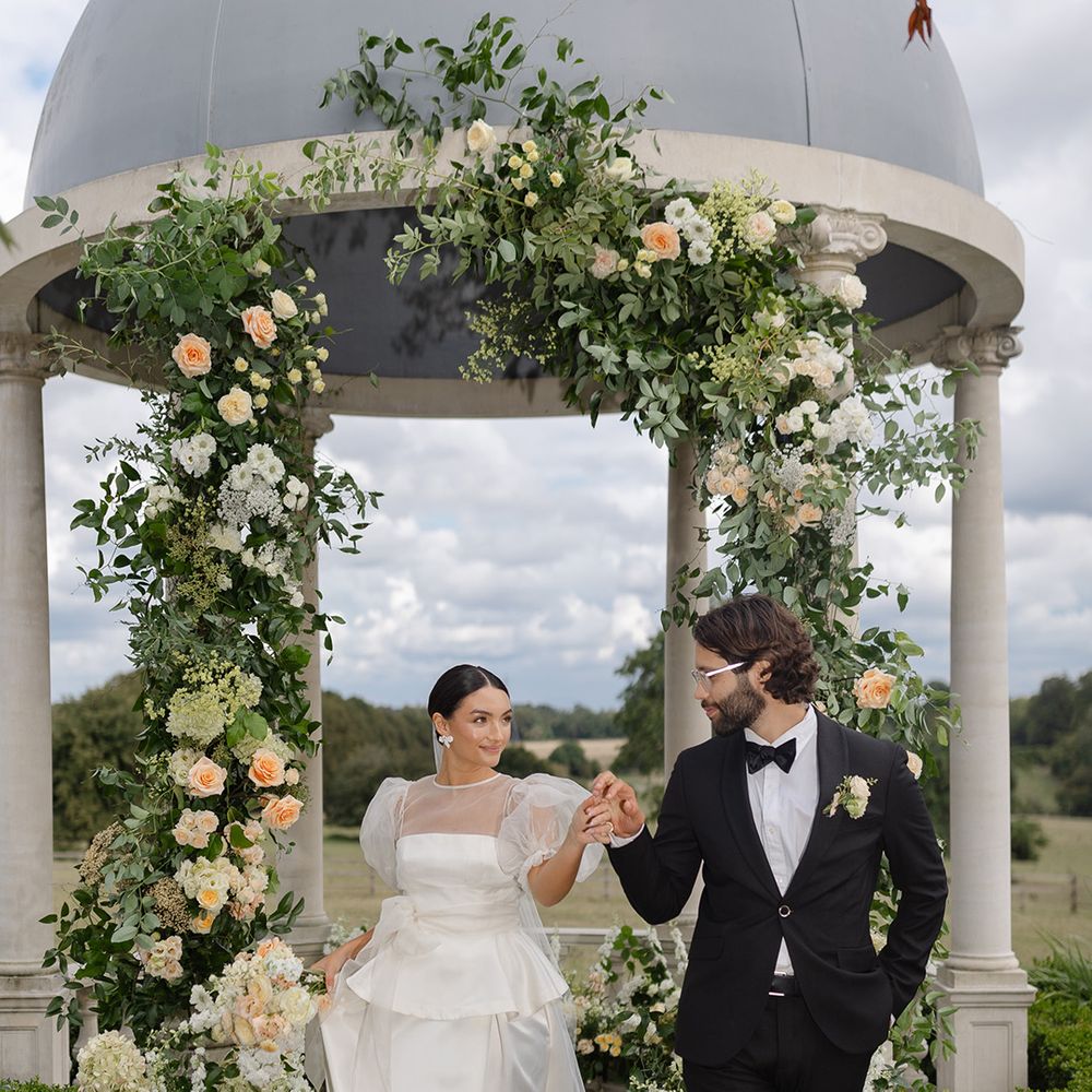 bride-in-peplum-wedding-dress-holding-hands-with-groom-for-outdoor-wedding