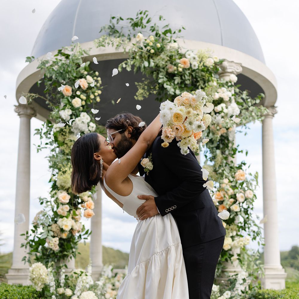 confetti-falls-over-the-bride-and-groom-as-they-kiss