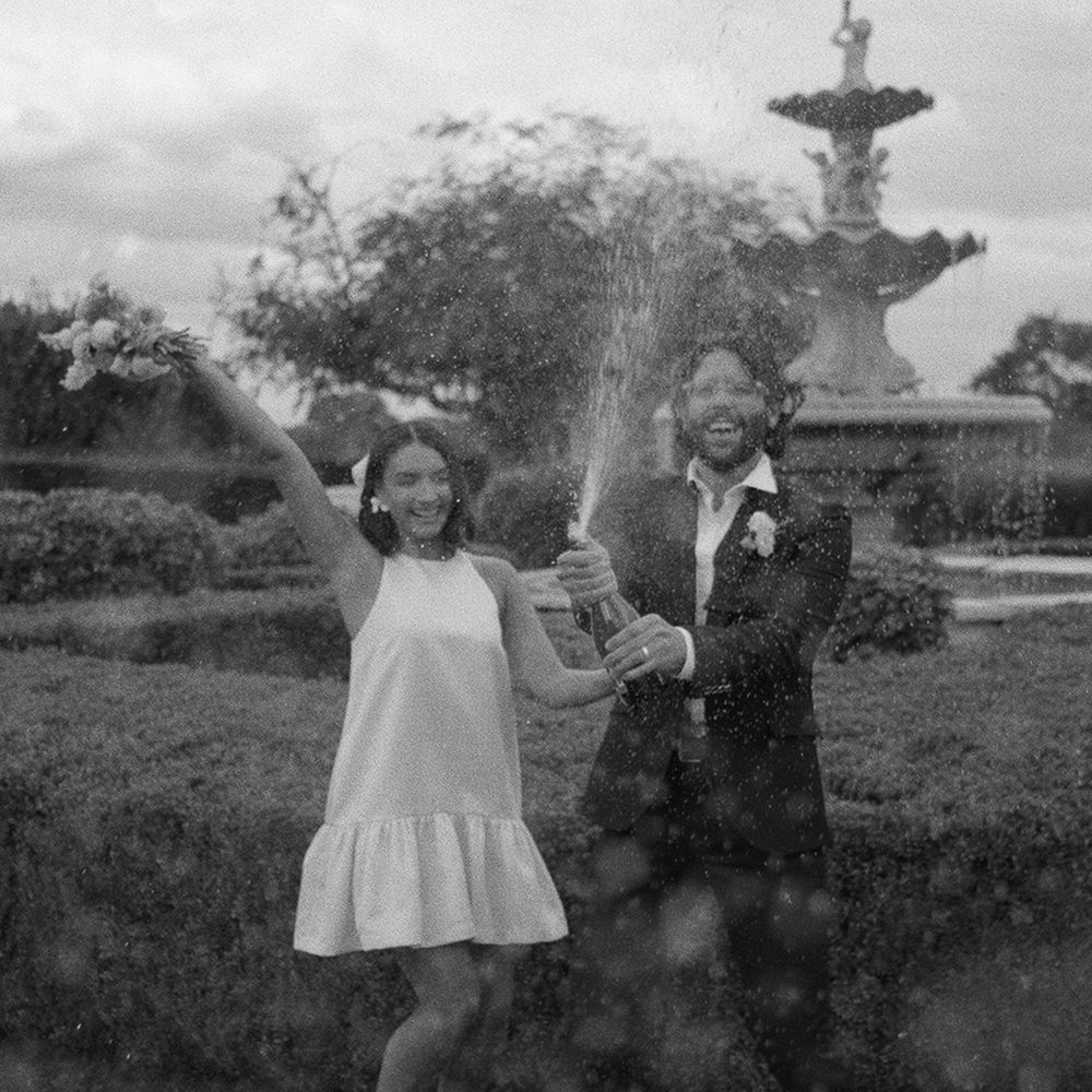groom-sprays-bottle-of-champagne-in-celebration