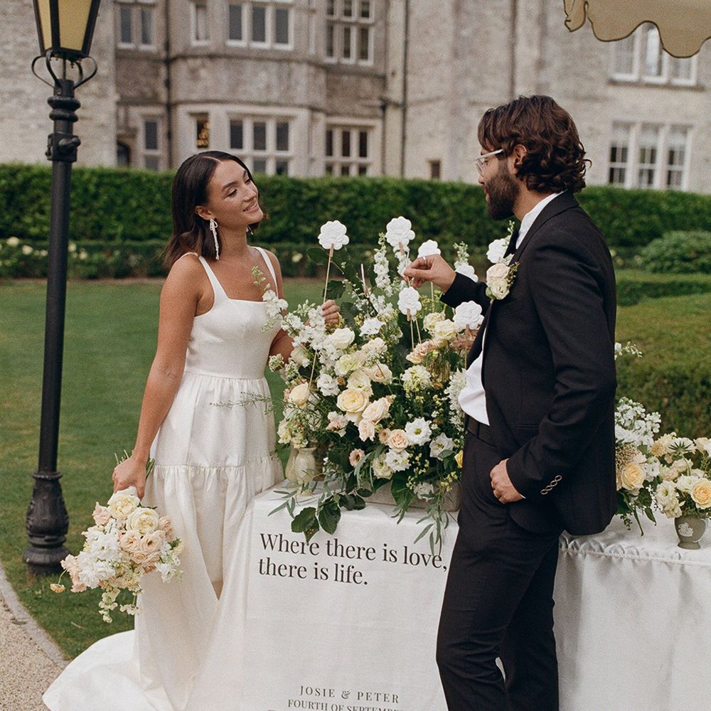 yellow-peach-and-white-wedding-flowers-with-bride-and-groom-smiling