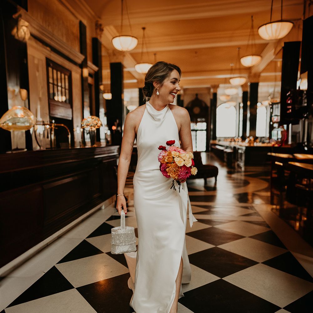 bride-carrying-sparkly-bridal-bag-with-pink-bouquet-in-satin-wedding-dress