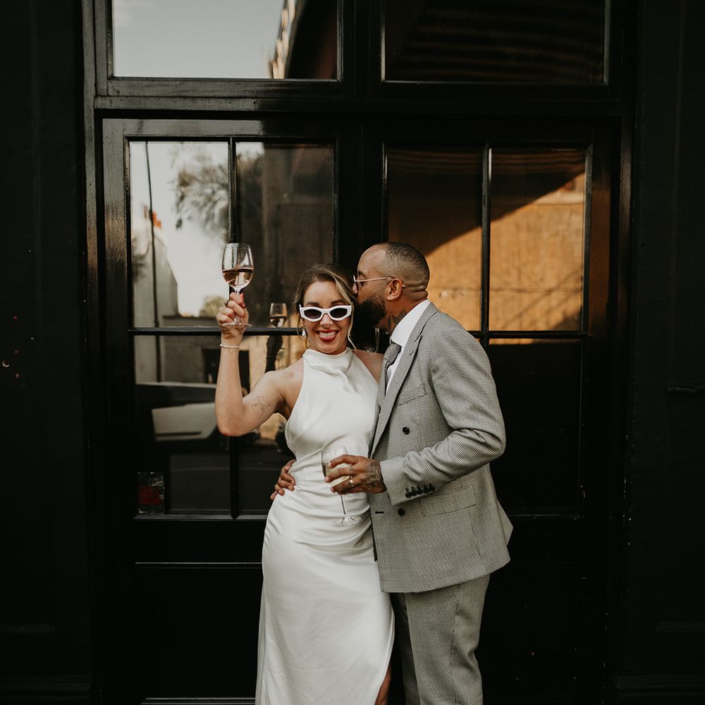 bride-in-halter-neck-satin-dress-with-groom-in-grey-suit-at-london-wedding