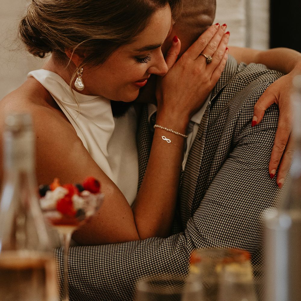 groom-embracing-bride-for-intimate-moment-at-wedding-breakfast