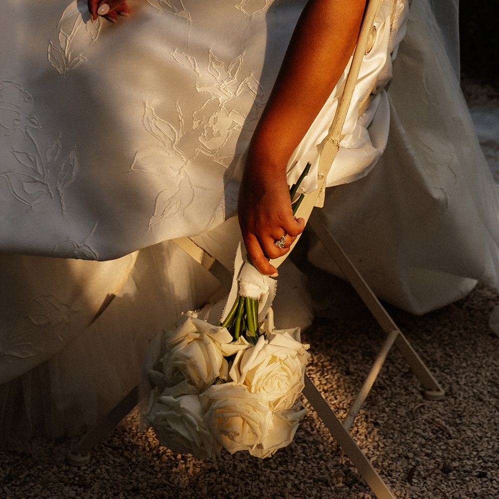 bride-wearing-floral-embroidered-wedding-dress-with-white-rose-bouquet