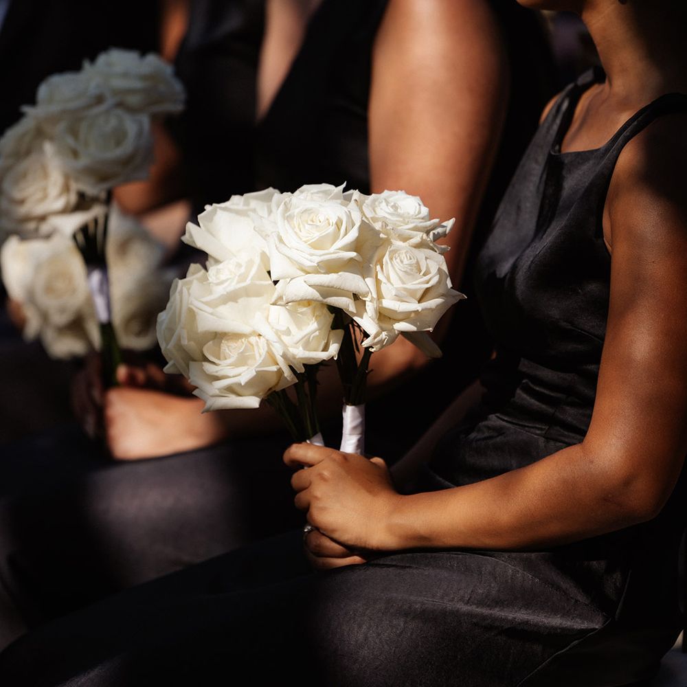 bridesmaids-in-black-satin-dresses-holding-white-rose-bouquet