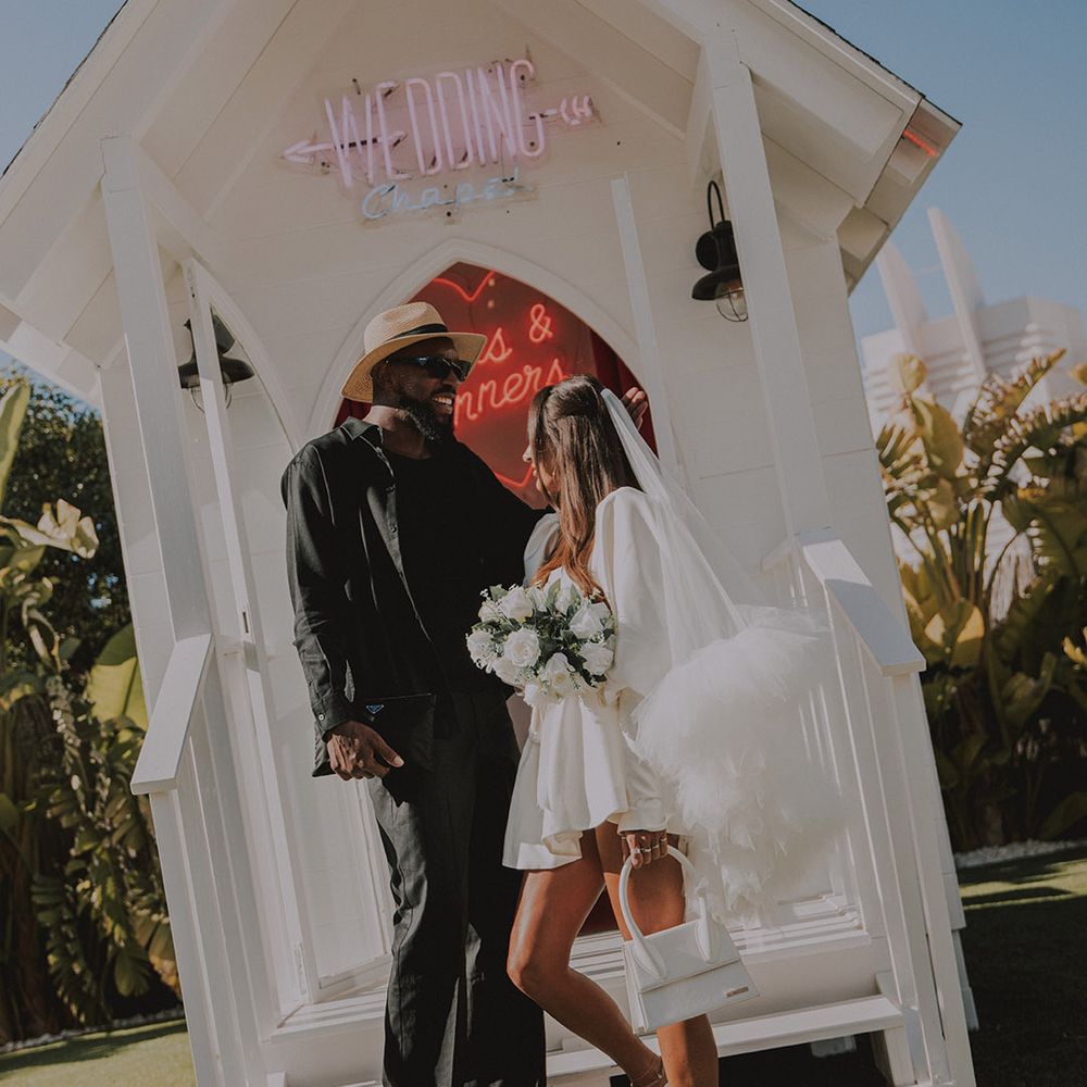 bride-in-short-wedding-dress-with-white-bag-and-shoes-with-groom
