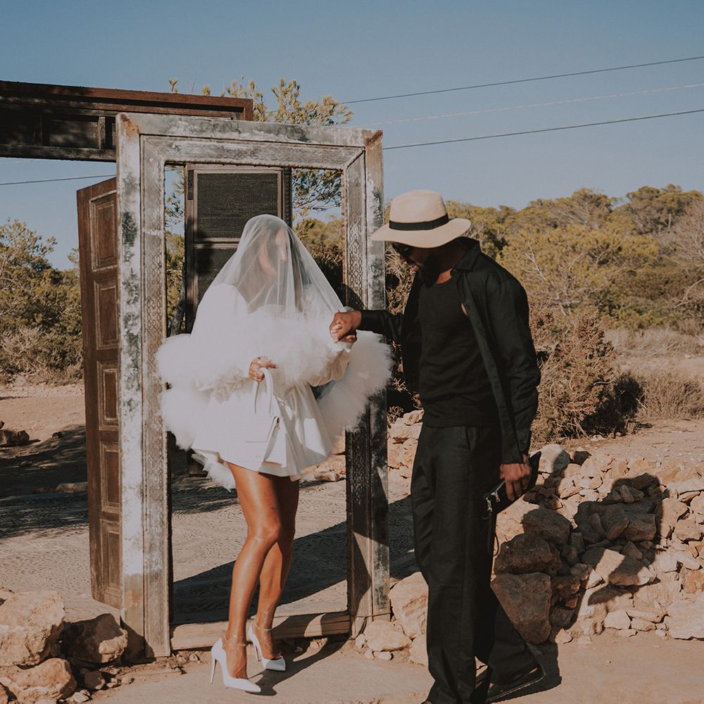 groom-in-dark-suit-with-hat-with-bride-in-short-wedding-dress-with-ruffle-veil