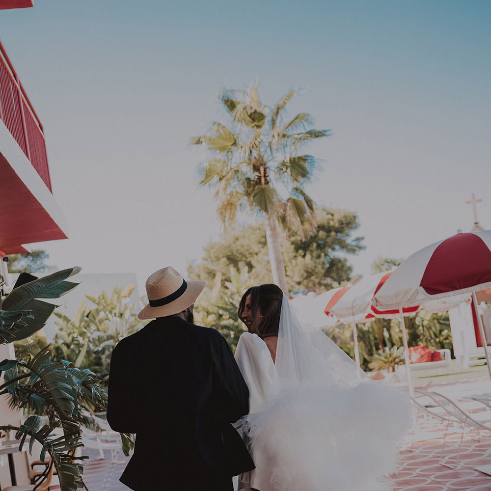 groom-walking-with-bride-in-short-wedding-dress-with-ruffle-veil