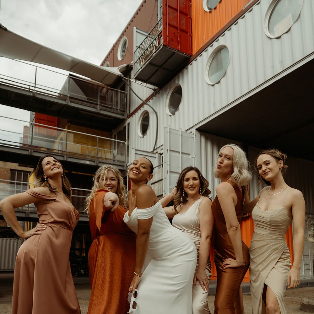 bridal-party-wearing-mismatched-autumnal-bridesmaid-dresses-with-bride-in-off-the-shoulder-wedding-dress