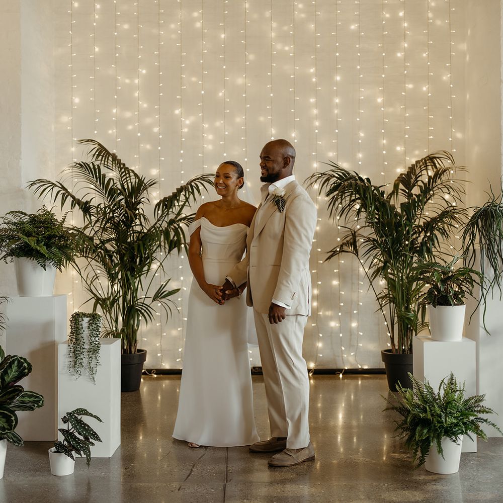 bride-and-groom-standing-at-altar-decorated-with-greenery