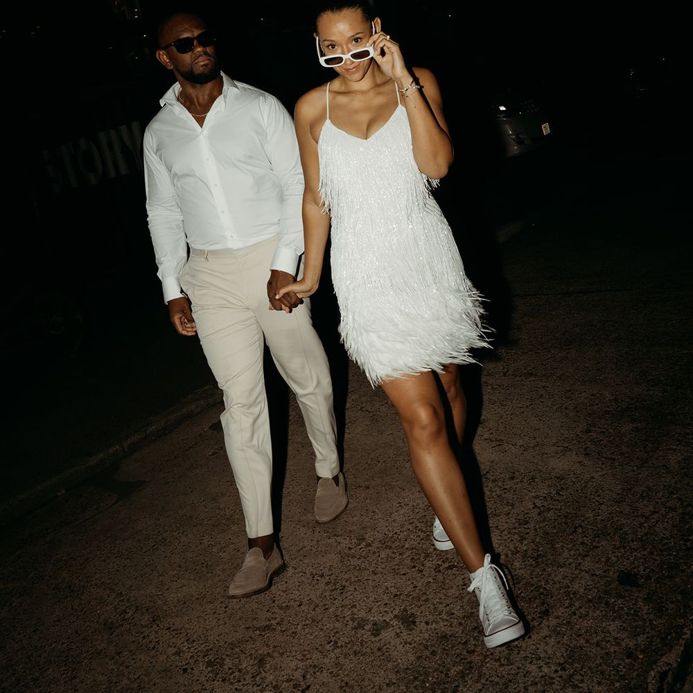 bride-in-white-tassel-wedding-dress-with-converses-walking-with-groom