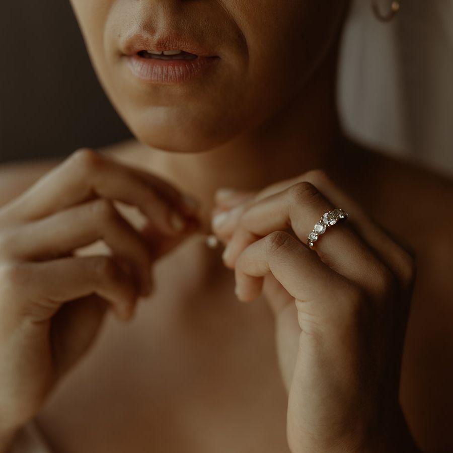 bride-putting-on-wedding-necklace-with-diamond-ring