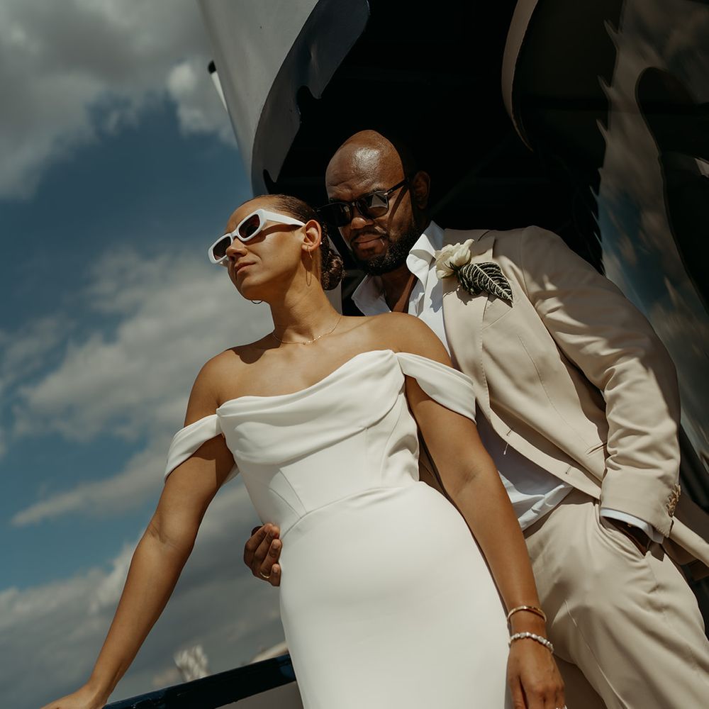 groom-in-cream-suit-embracing-bride-in-martina-liana-wedding-dress-with-sunglasses