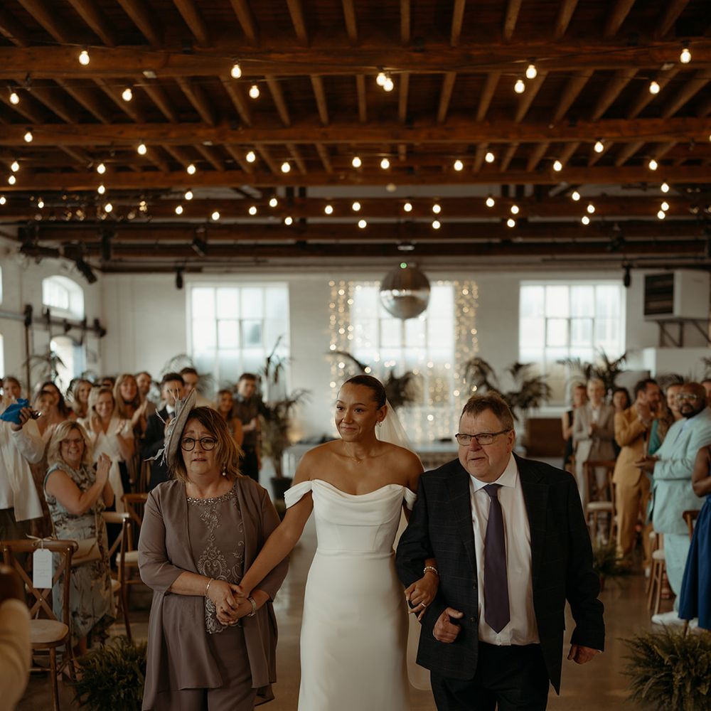 mother-and-father-of-the-bride-walking-her-down-the-aisle