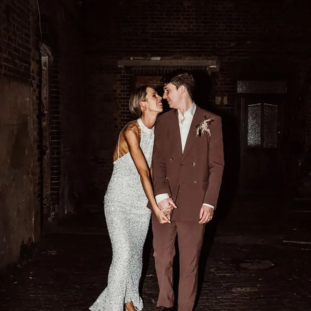 Bride in sparkly evening wedding dress with groom in brown wedding suit
