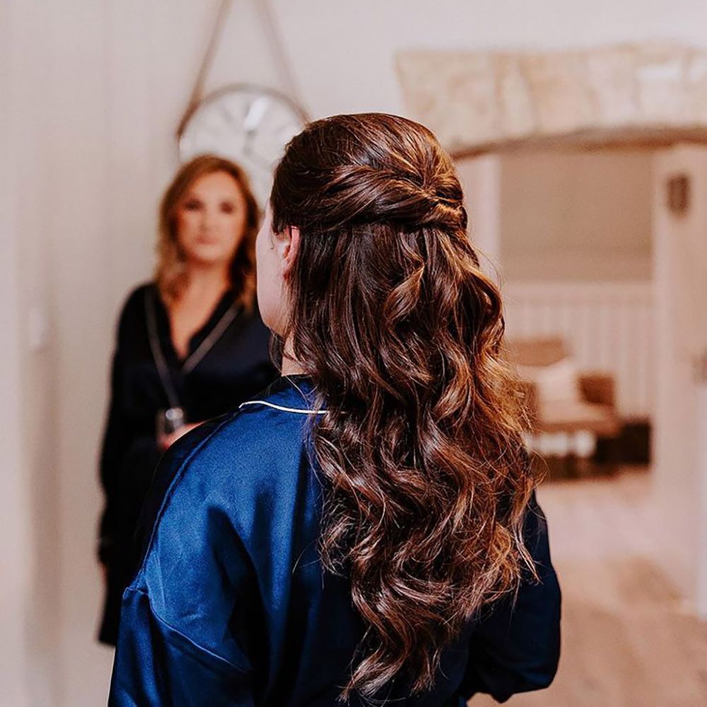 bride wearing dark blue satin bridal robe on wedding morning