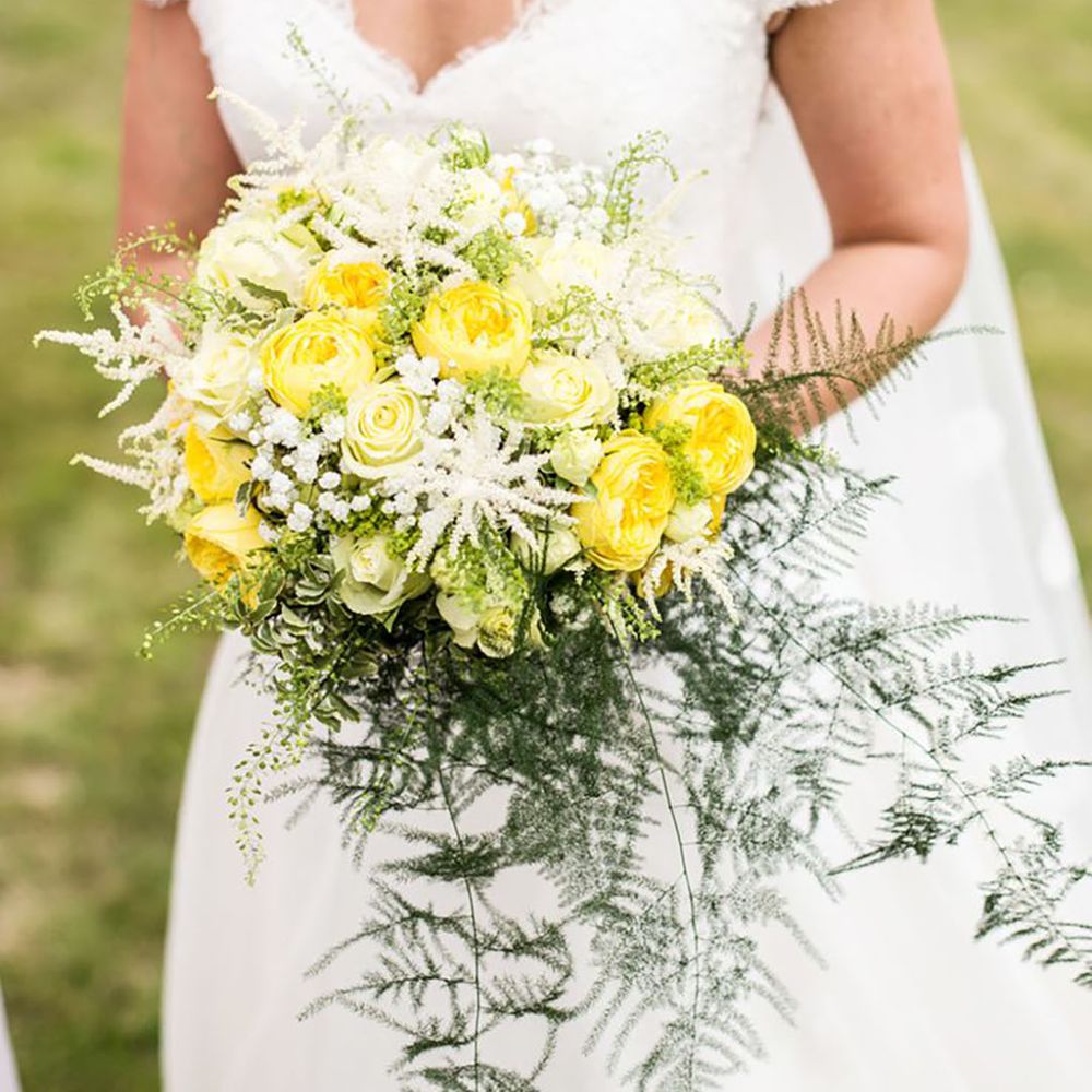 bride holding a wedding bouquet with bright yellow flowers
