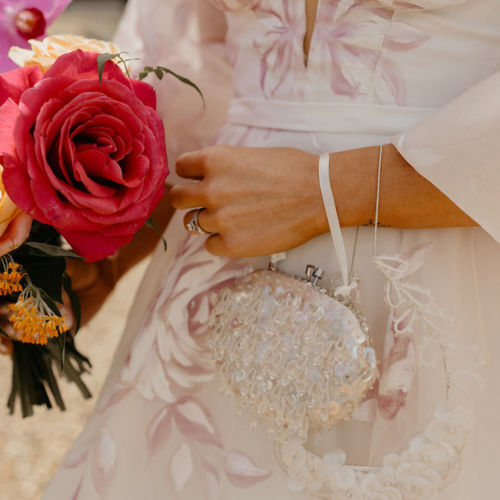 bride-carrying-beaded-bridal-bag-with-rose-bouquet