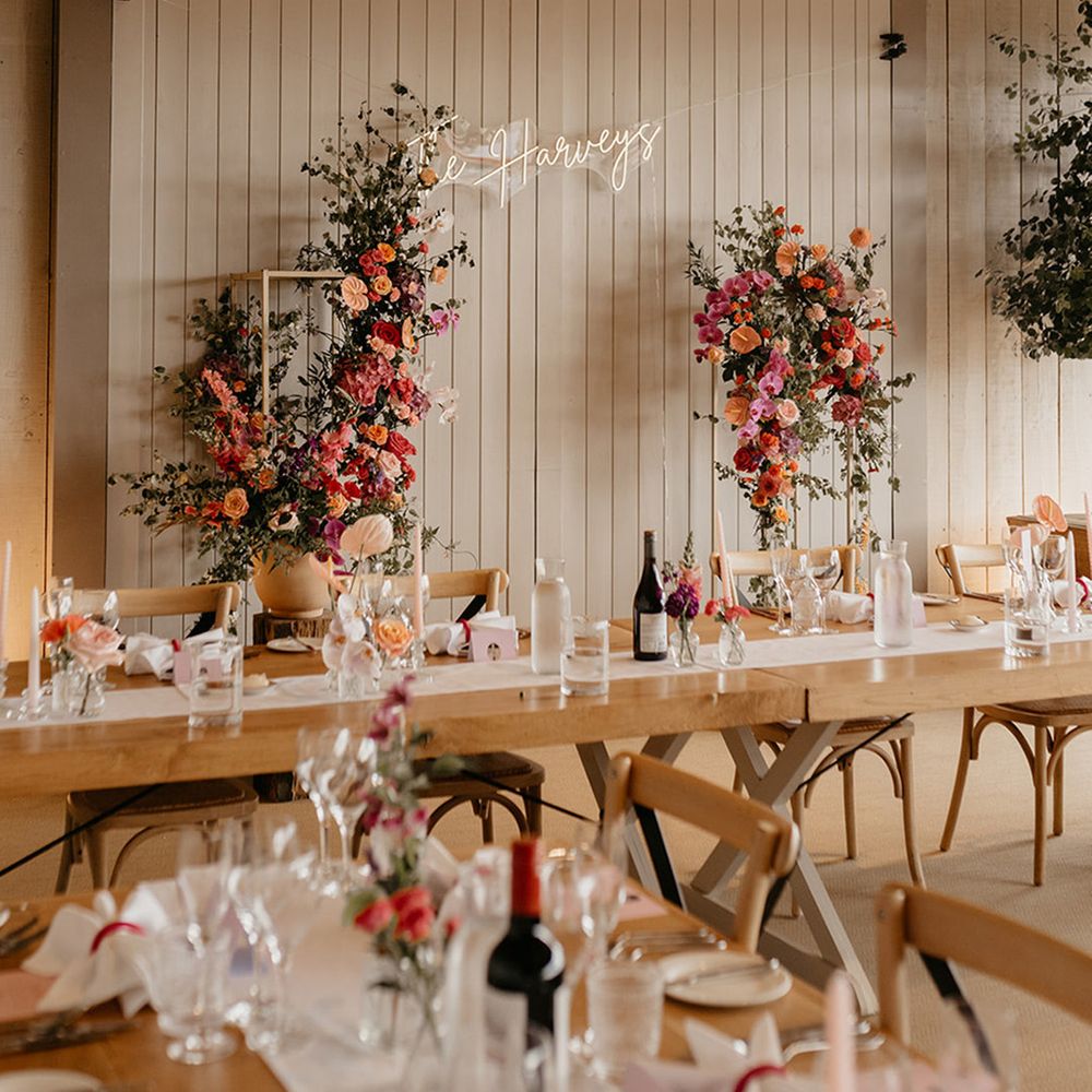 coral-and-pink-wedding-column-flower-arrangements-with-neon-sign