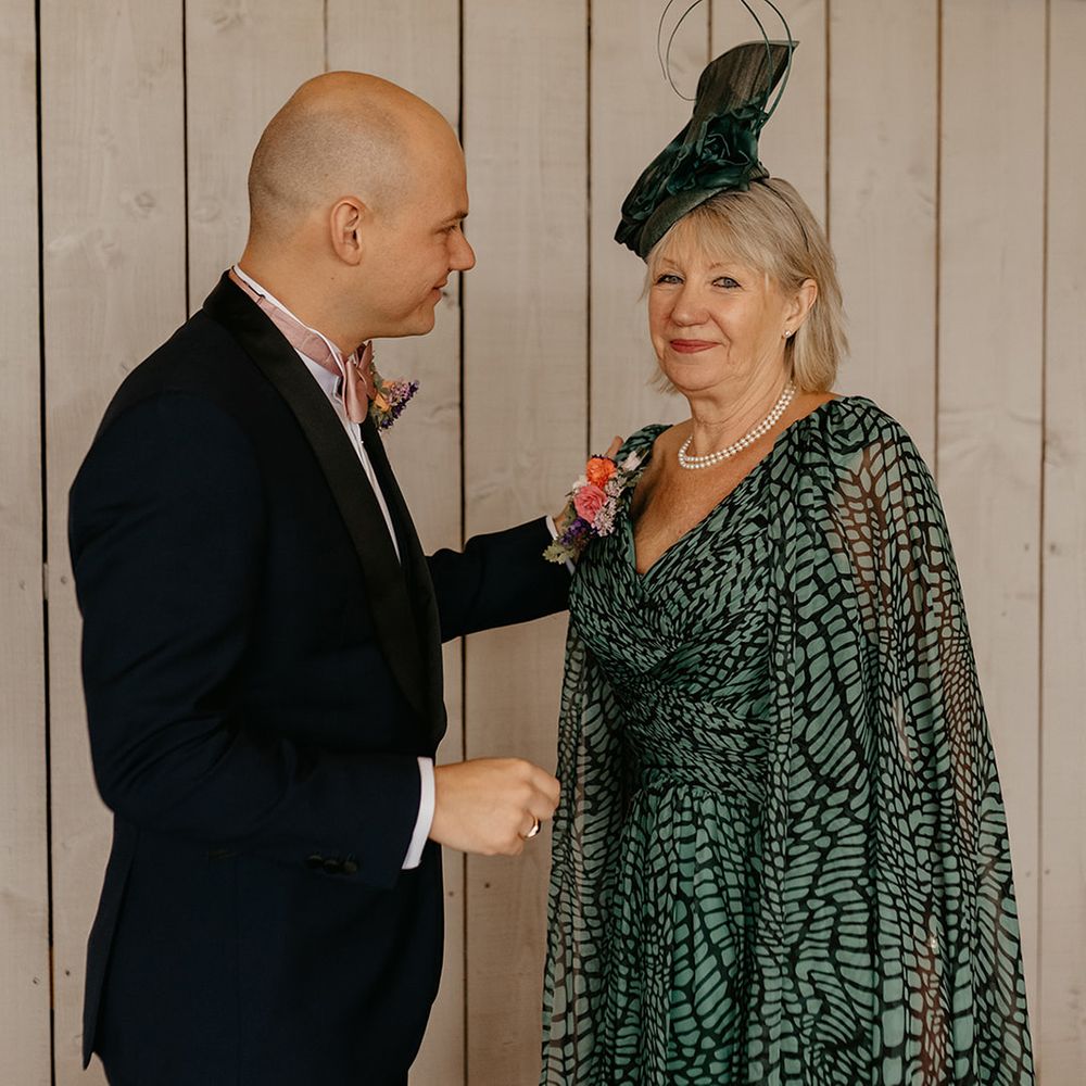 mother-of-the-groom-wearing-black-and-green--dress-and-cape
