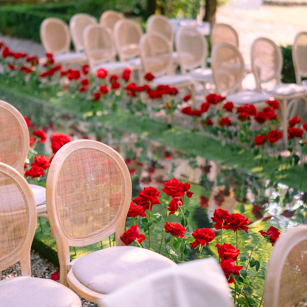 wicker-wedding-chairs-with-red-flowers-decorating-the-aisle