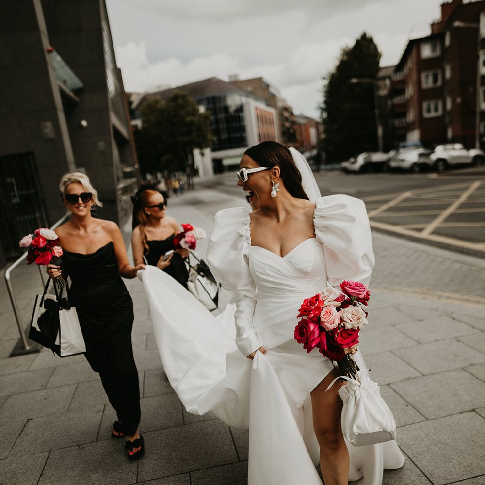 bride-wearing-puff-sleeve-wedding-dress-walking-with-bridal-party-in-black-bridesmaid-dresses