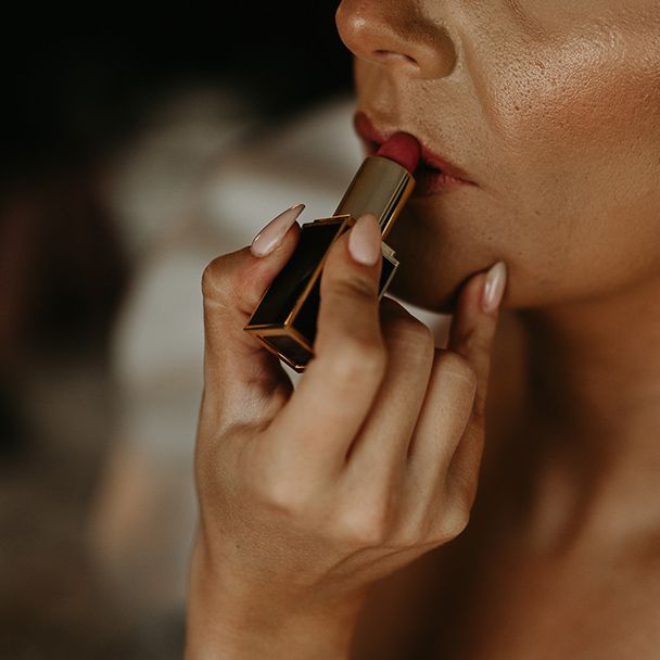 statement-bridal-earrings-with-bride-putting-on-lipstick