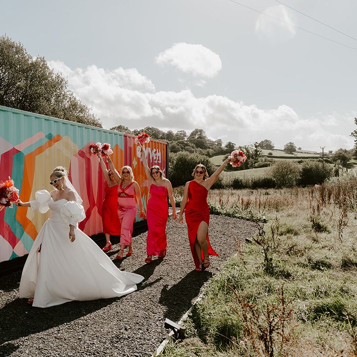 bride-walks-with-bridesmaids-in-colourful-dresses