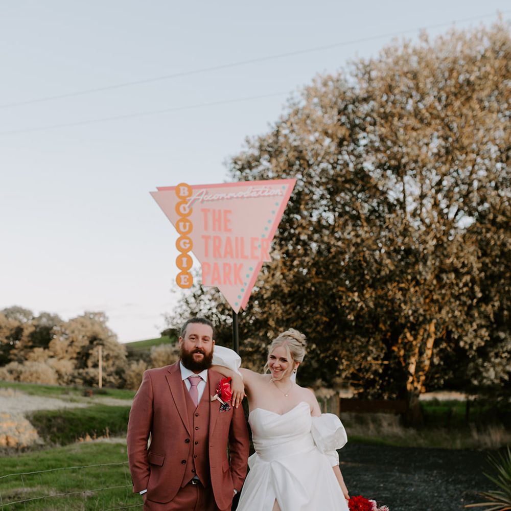 bride-wearing-front-slit-wedding-dress-with-red-garter-with-groom-in-pink-suit