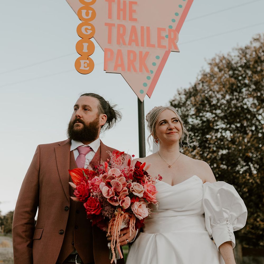 pastel-wedding-signage-with-bride-and-groom-posing-together