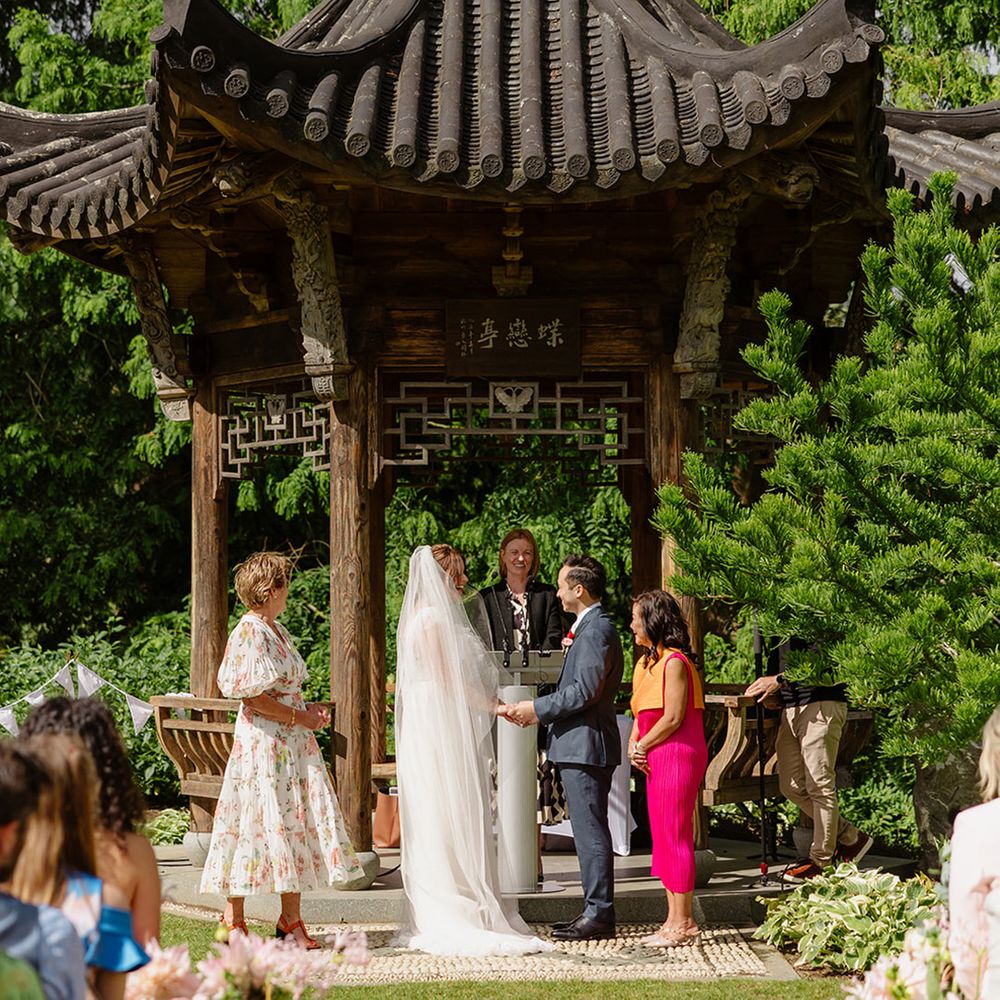 bride-and-groom-exchange-vows-at-wisley-gardens-wedding-venue