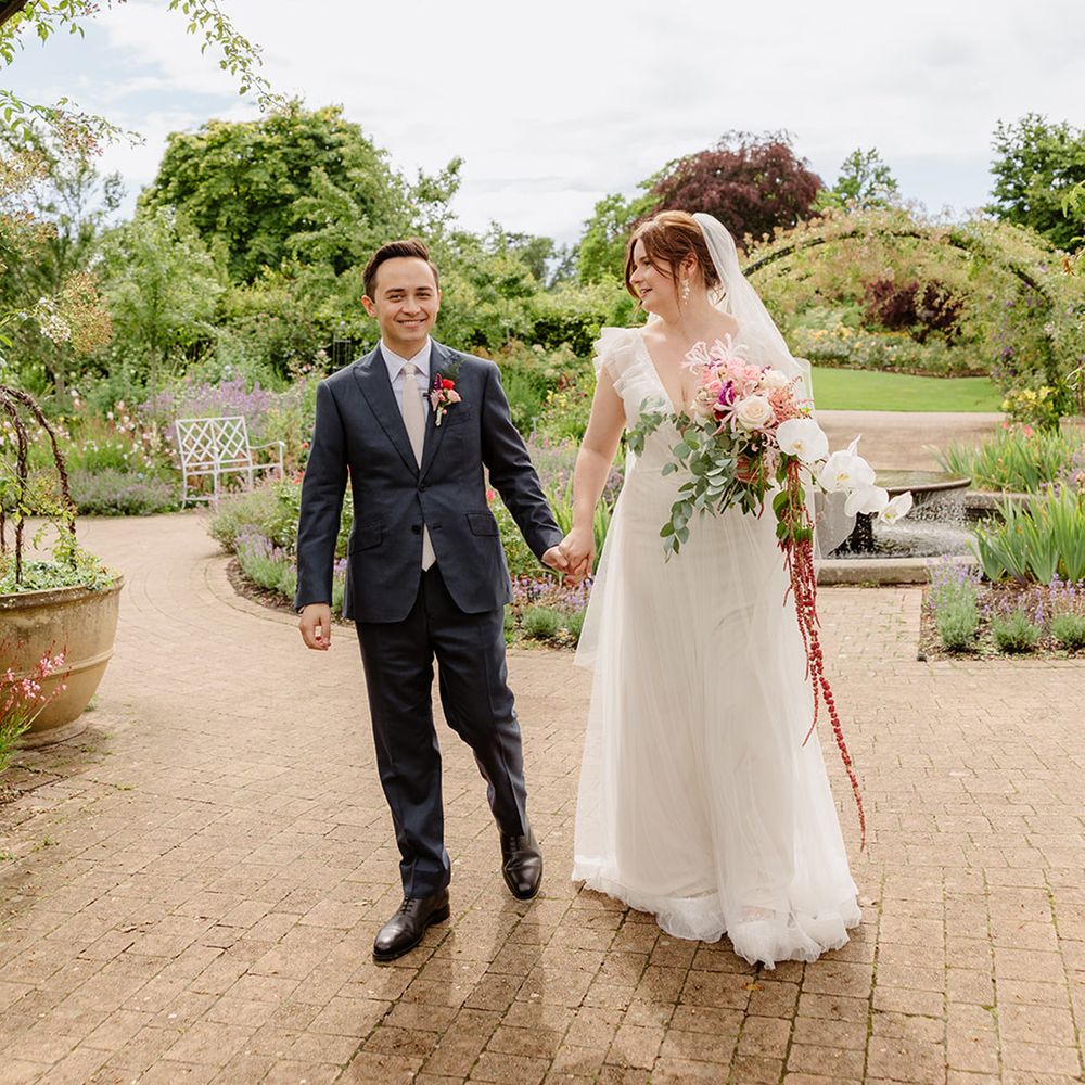 bride-and-groom-walk-holding-hands-for-wedding-day