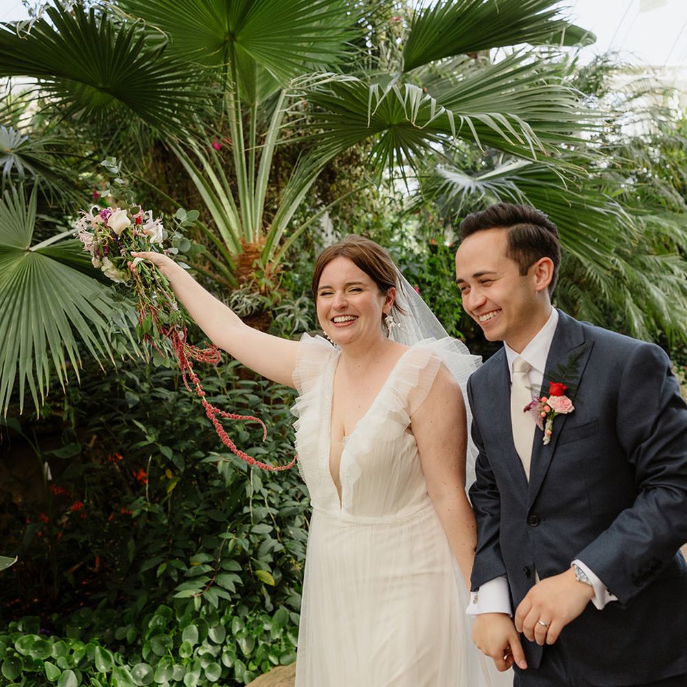 bride-in-ruffle-wedding-dress-with-groom-in-blue-suit-at-botanical-wedding