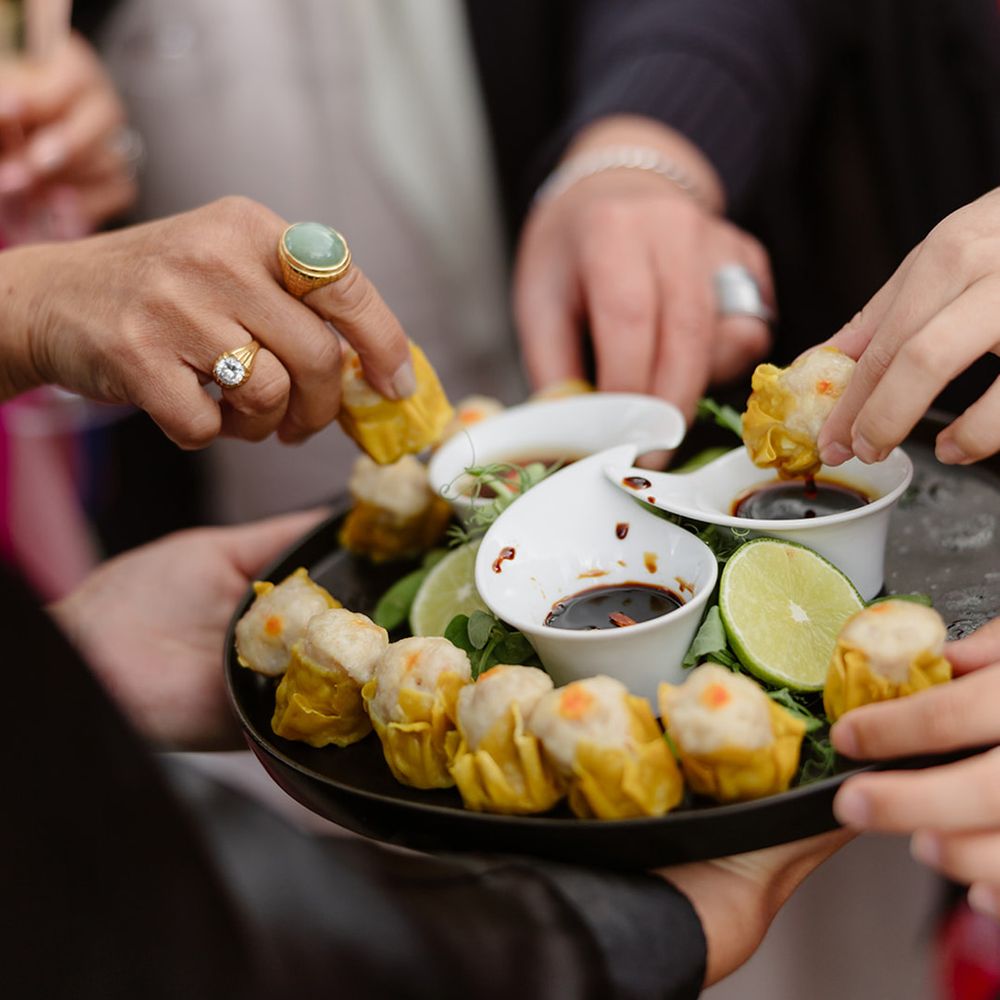 wedding-guests-dip-dumplings-into-soy-sauce