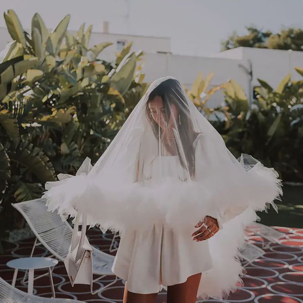 bride wearing a long sleeve short Cupid Blue Bridal hen party dress idea and ruffle veil