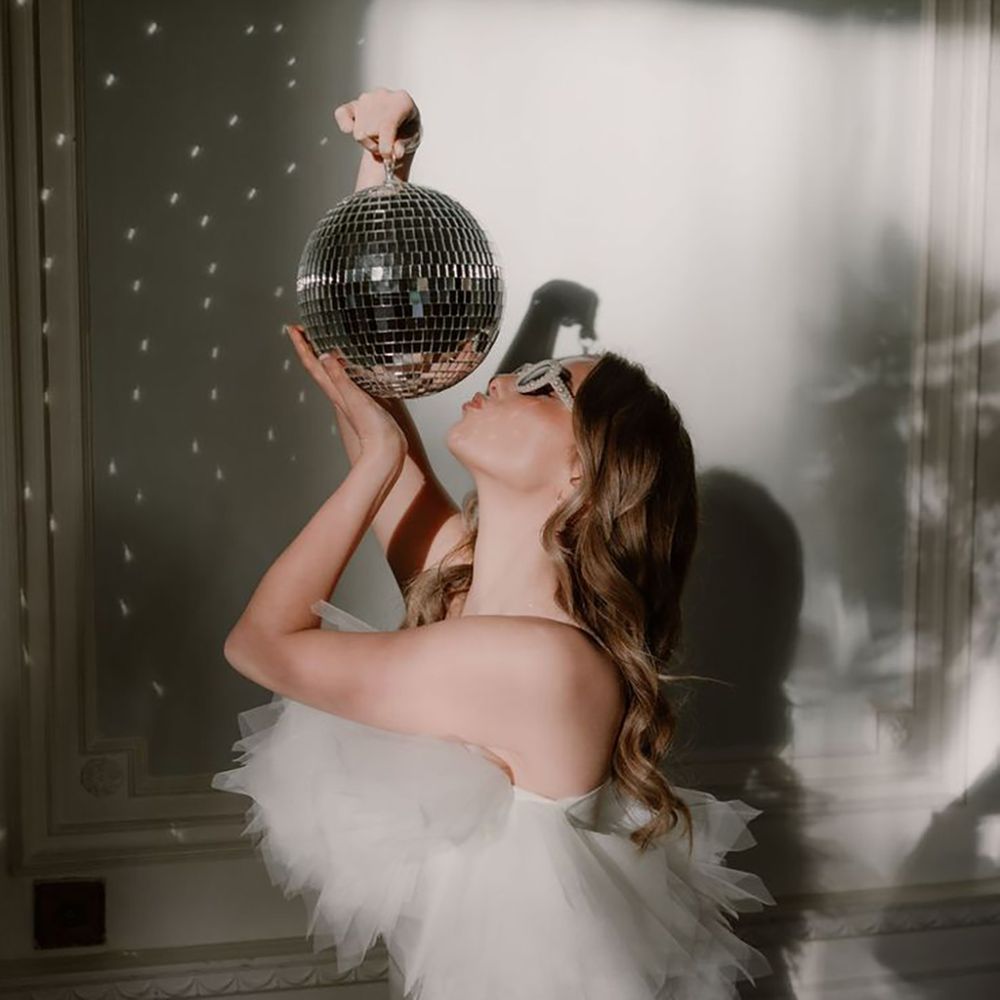 Cupid Blue Bridal Collection short hen party dress idea with tulle neckline holding disco ball