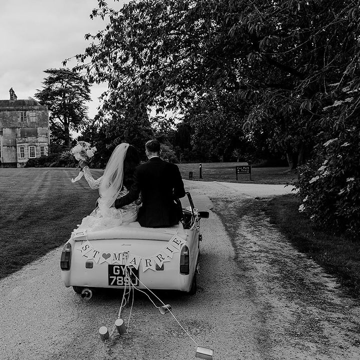 bride-and-groom-riding-on-wedding-car-at-elmore-court