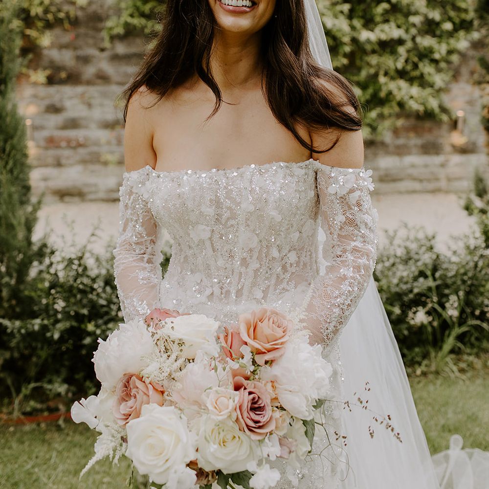 bride-in-sparkly-off-the-shoulder-wedding-dress-with-pale-pink-bouquet