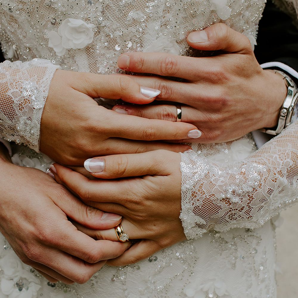 bride-with-french-tip-wedding-nails-holding-hands-with-groom