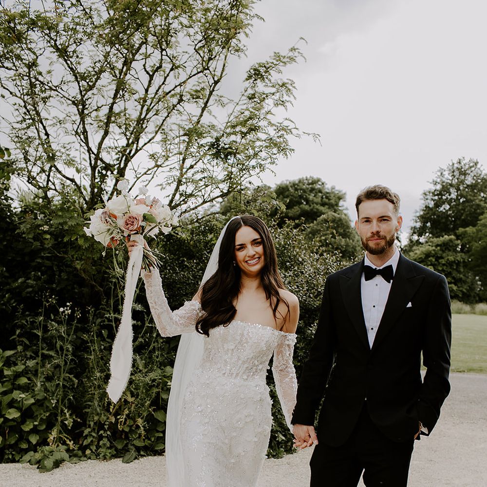 groom-in-black-tux-walking-with-bride-in-sparkly-wedding-dress