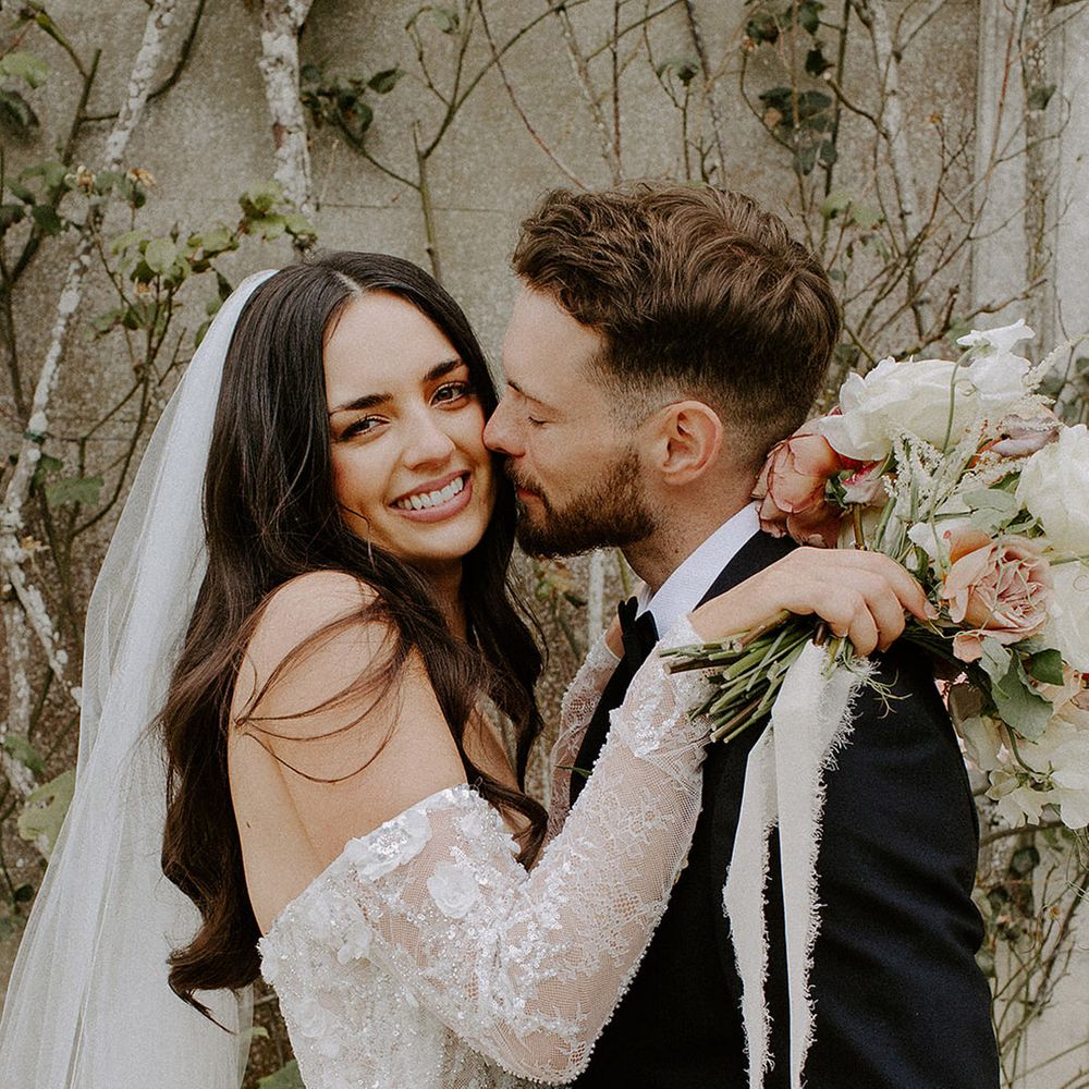 groom-kisses-bride-with-long-hair-in-lace-wedding-dress