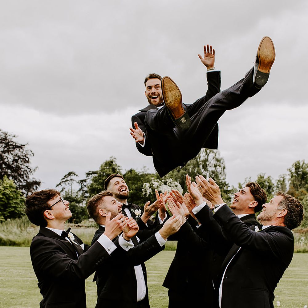 groomsmen-lifting-groom-up-into-the-air-in-funny-photo