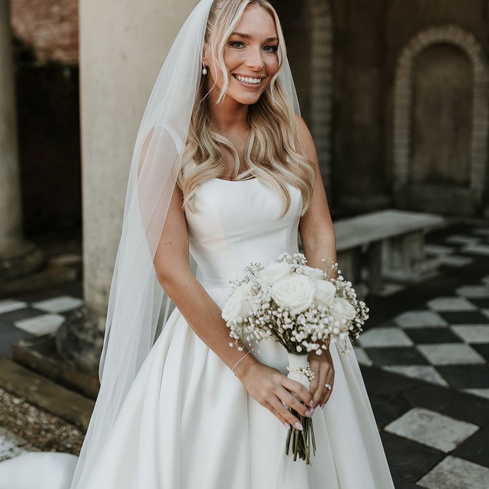 bride-carries-white-wedding-bouquet-in-princess-wedding-dress