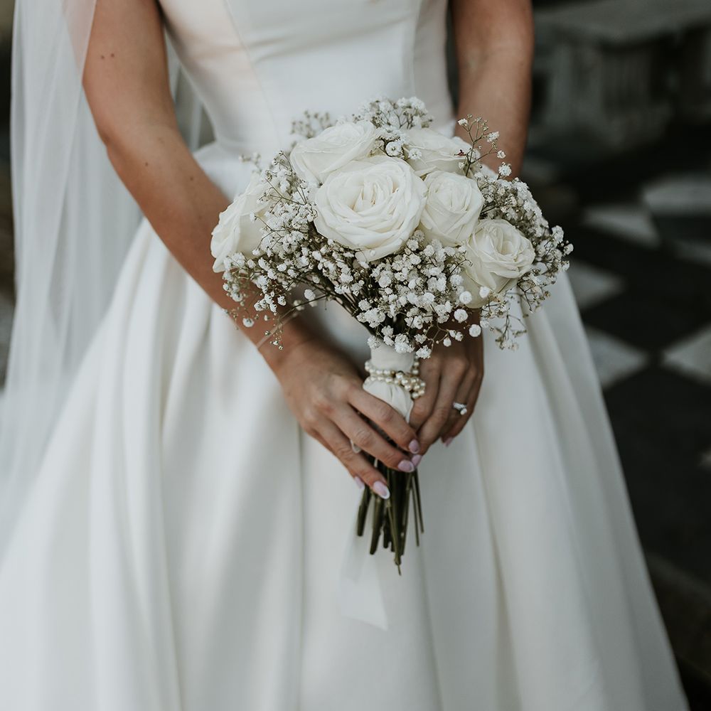 bride-carrying-white-rose-and-gypsophila-bouquet