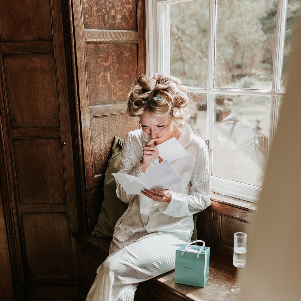 bride-gets-emotional-reading-letter-and-opening-gift-morning-of-the-wedding