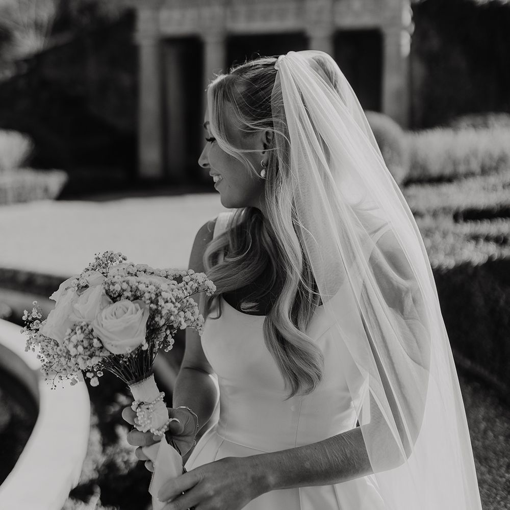 bride-wears-wedding-veil-holding-white-bouquet