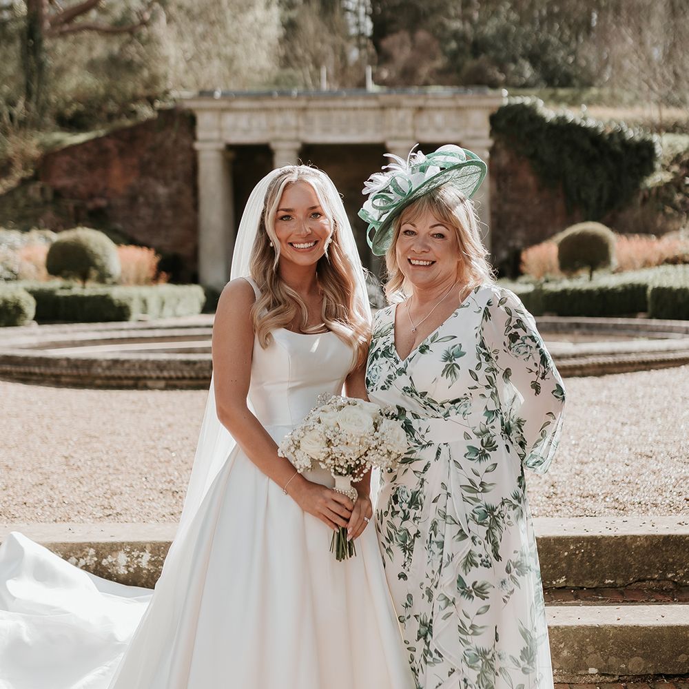 mother-of-the-bride-in-blue-floral-dress-with-bride-in-princess-wedding-dress