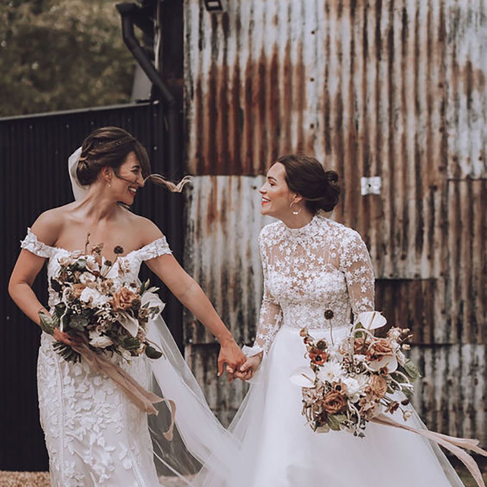 two brides on their wedding day wearing off-shoulder and high neck lace wedding dresses